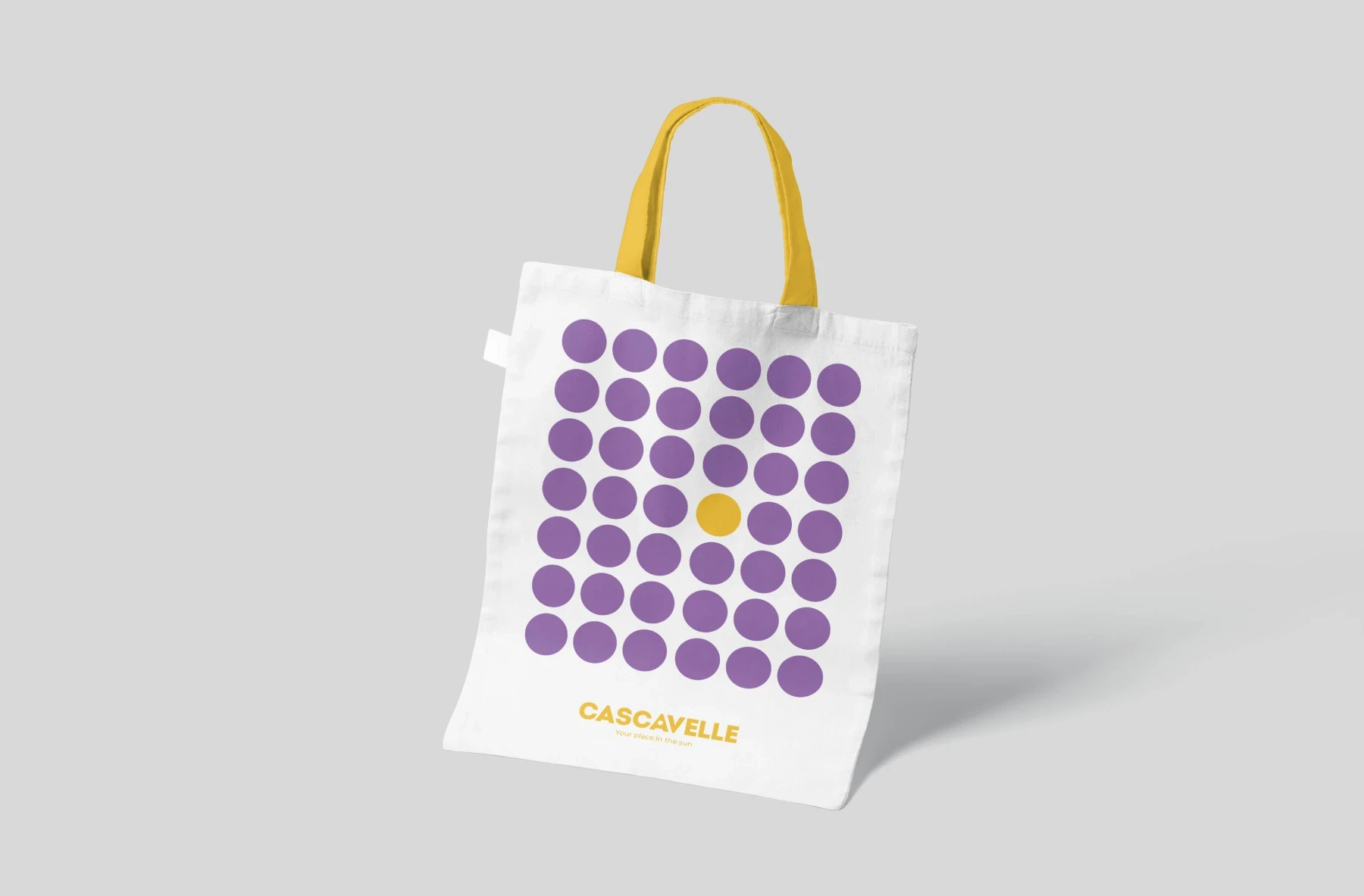 Tote bag Cascavelle à points violets et anses jaunes.